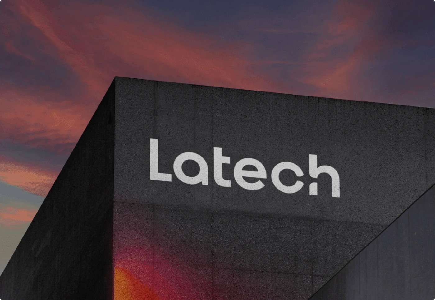 Latech (now Stravos) startup logo design on headquarters building facade, during sunset. Tech startup rebrand by Fabio Besti and Nemesis Agency
