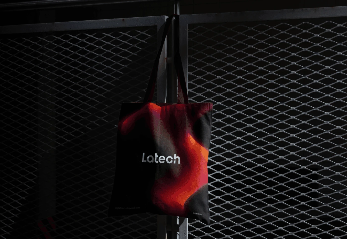 Mockup of a branded tote bag displaying the logo design of Latech. Realized for the Latech (Stravos) project, a tech startup rebrand by Fabio Besti and Nemesis Agency.